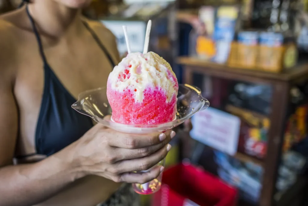 Pink and white shave ice held in a clear dish